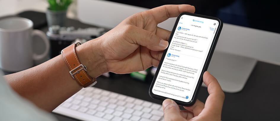 Hands holding a phone submitting for work on Central Casting jobs page.