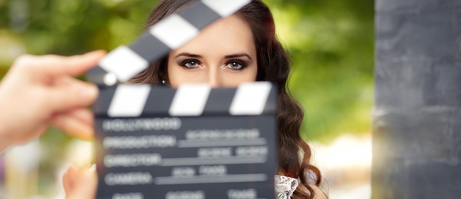 Casting terms on a clapperboard in front of an actress.