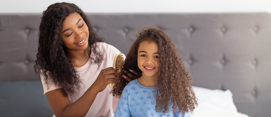 Mother getting her child's hair camera ready.