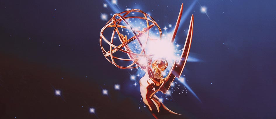 Emmy Awards statue with a light burst on a blue background.