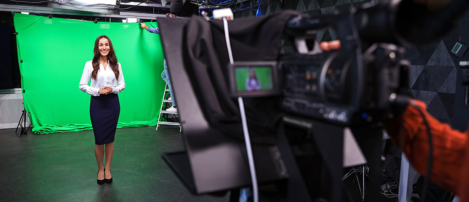 Woman on production set standing in front of a camera.