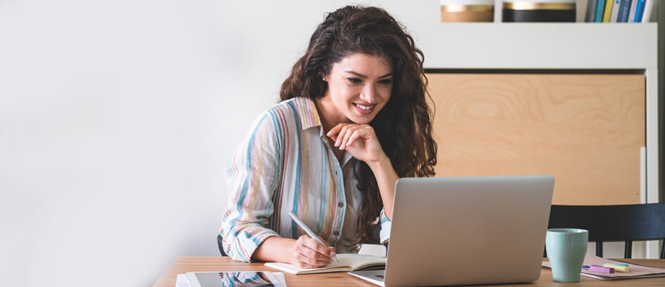 A woman watching Virtual Visiting on a laptop.