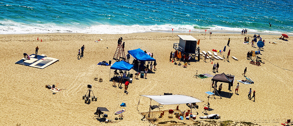 Background Actors working summer jobs during a beach film shoot.