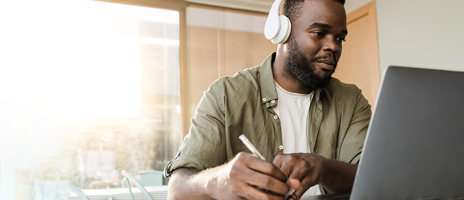 Man attending Virtual Visiting and taking notes.